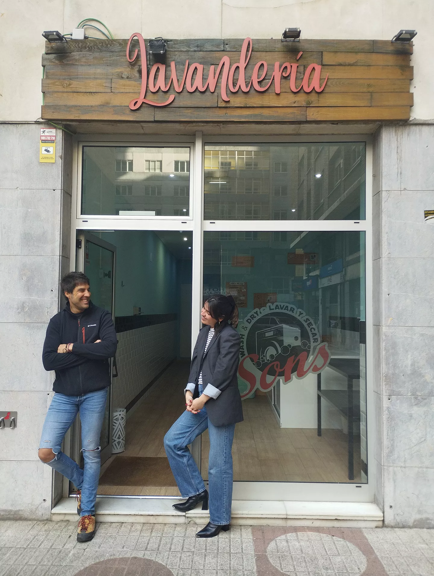 Hombre y mujer posando en puerta de lavandería